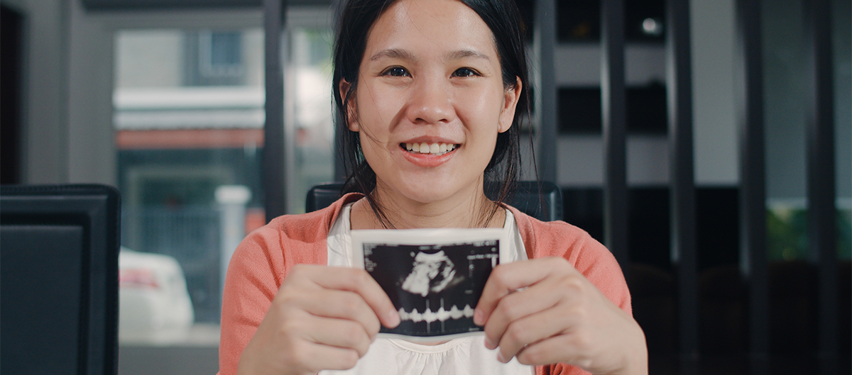 woman holding a picture of an ultrasound
