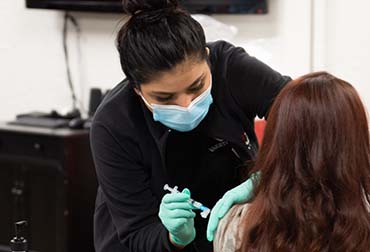 nurse-administering-covid-vaccine Nurse administering COVID-19 vaccine